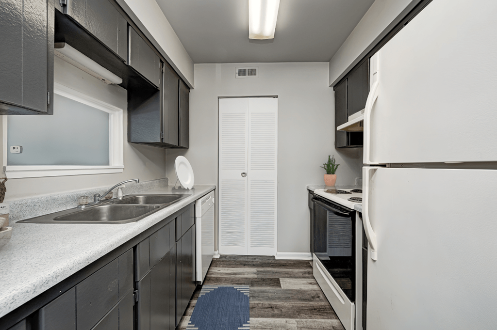 a kitchen with black cabinets and white appliances and a white refrigerator