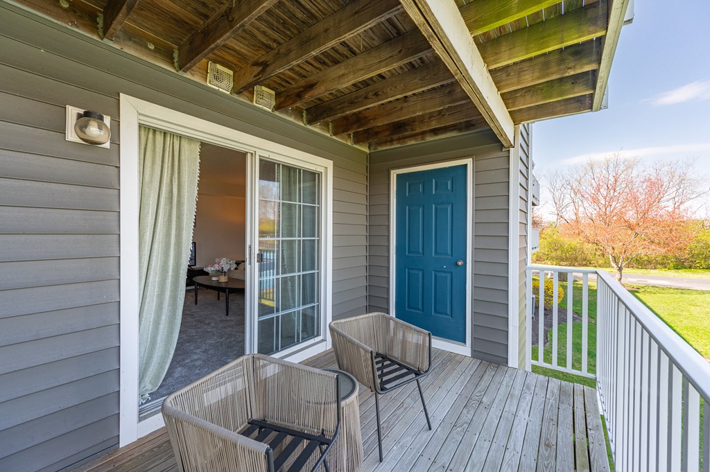 Covered porch with two chairs and a blue door at Wrights Point, Ft Wright