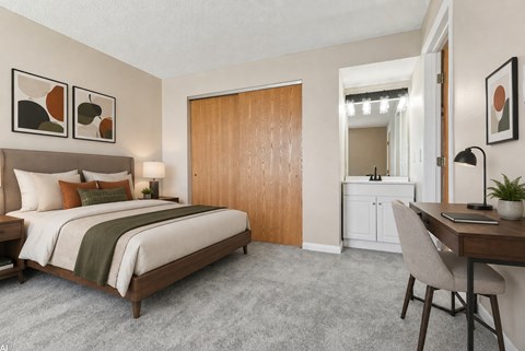 A bedroom with a bed, desk, and chair.