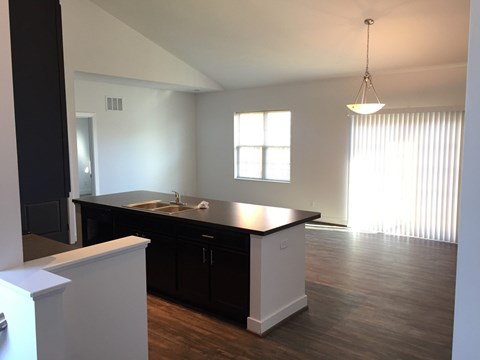 A kitchen with black cabinets and a white island.