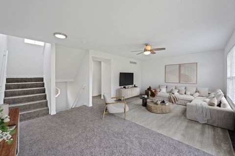 a living room with white walls and grey carpet