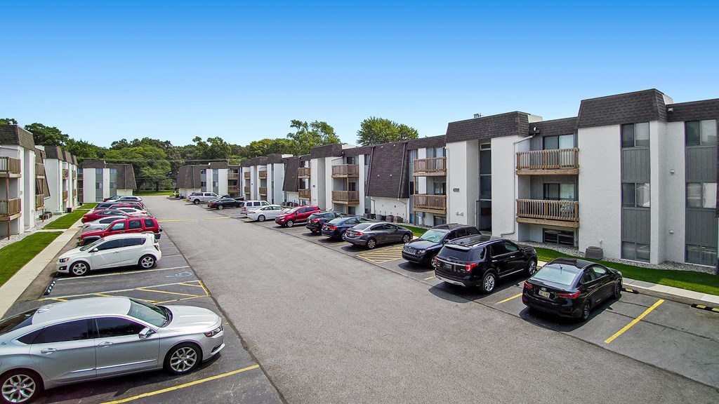 a row of apartment buildings with cars parked in front of them