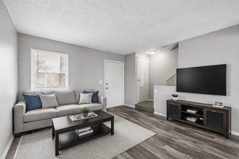 A living room with a grey couch, a coffee table, and a television. at Sharon Green Townhomes, Columbus, 43229