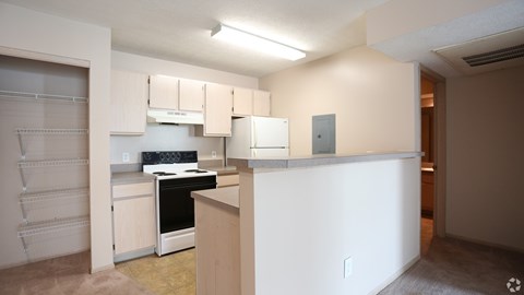 A kitchen with white cabinets and a stove top oven.