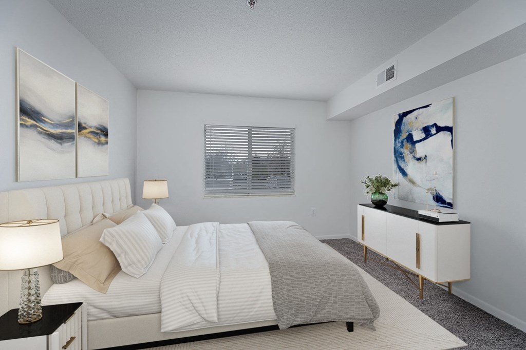 a white bedroom with a large bed and a white dresser