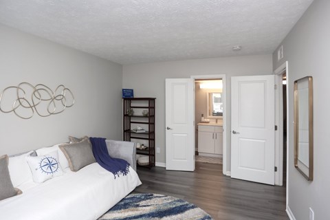 A white couch with a blue throw is in a living room.
