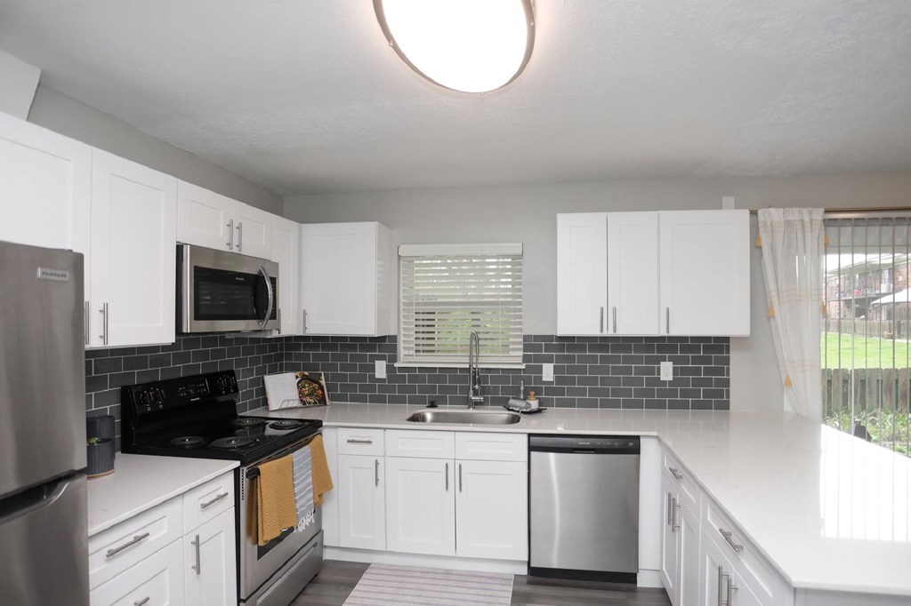 A kitchen with white cabinets and a black stove top oven.at Spinnaker Court, Indianapolis Indiana