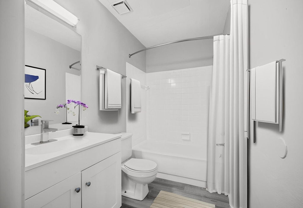 a white bathroom with a shower and a sink