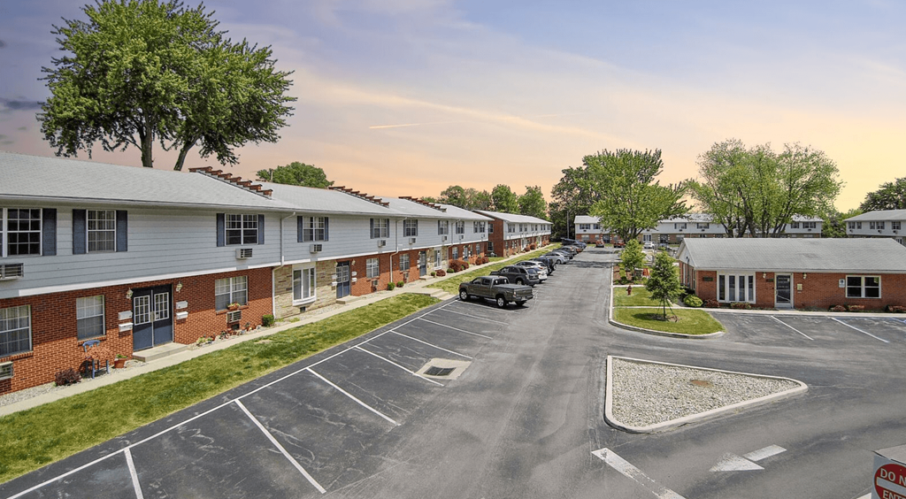 an empty parking lot in front of a row of apartment buildings
