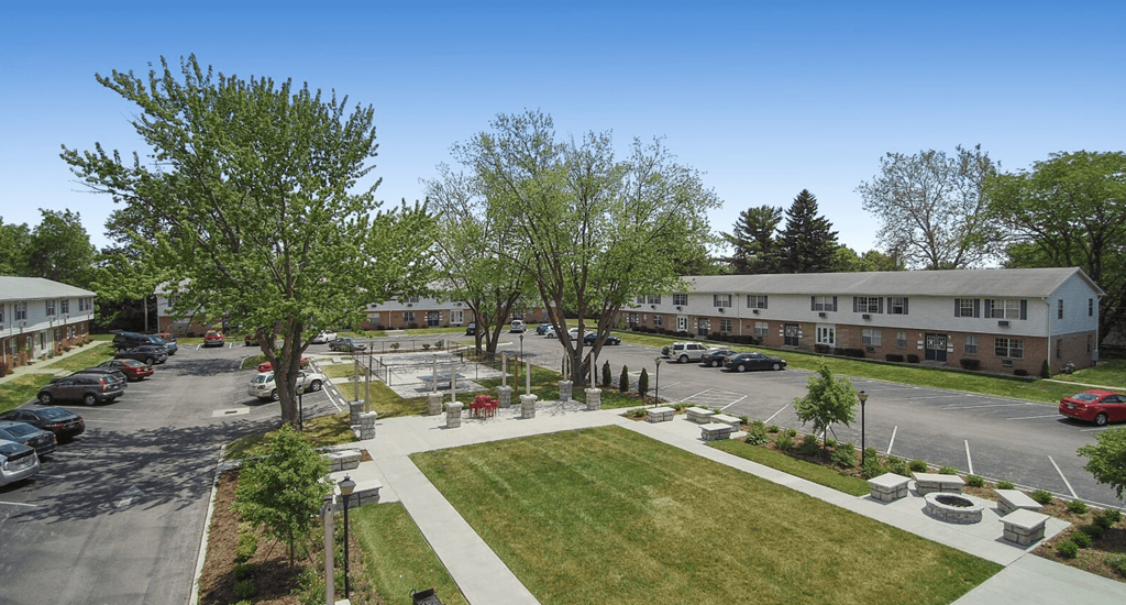 an aerial view of a parking lot with trees and buildings