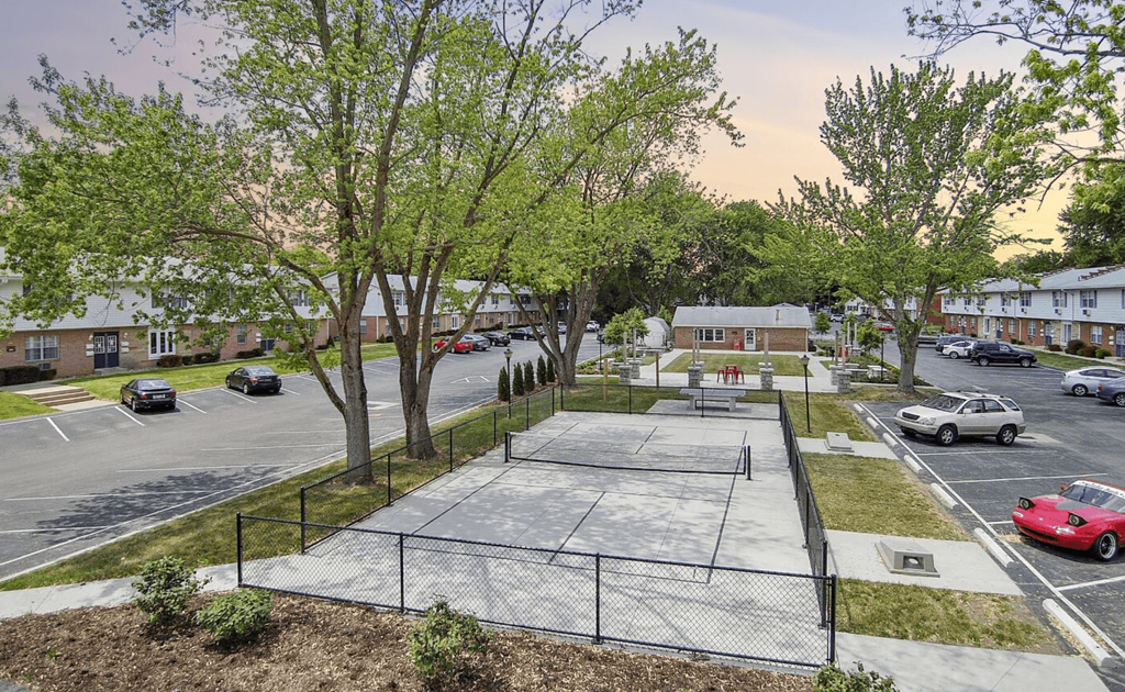 a tennis court in the middle of a parking lot