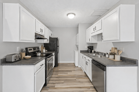 A kitchen with white cabinets and stainless steel appliances.