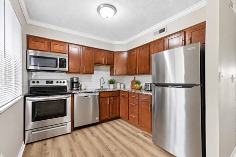 A kitchen with wooden cabinets and stainless steel appliances.