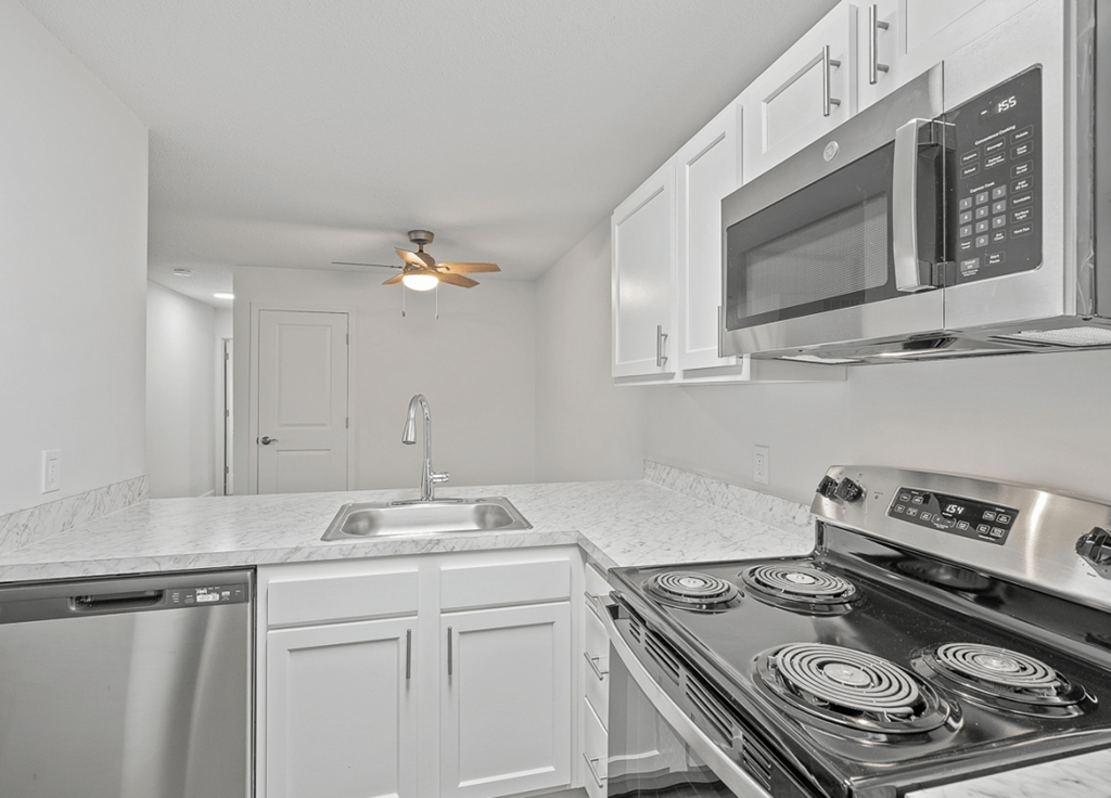 a kitchen with white cabinets and stainless steel appliances and a sink