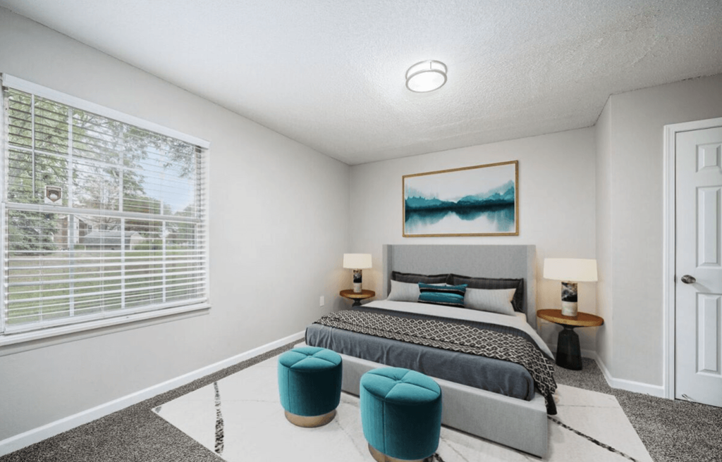 a bedroom with a bed and a large window at The Berryessa Apartments, Columbus, Ohio