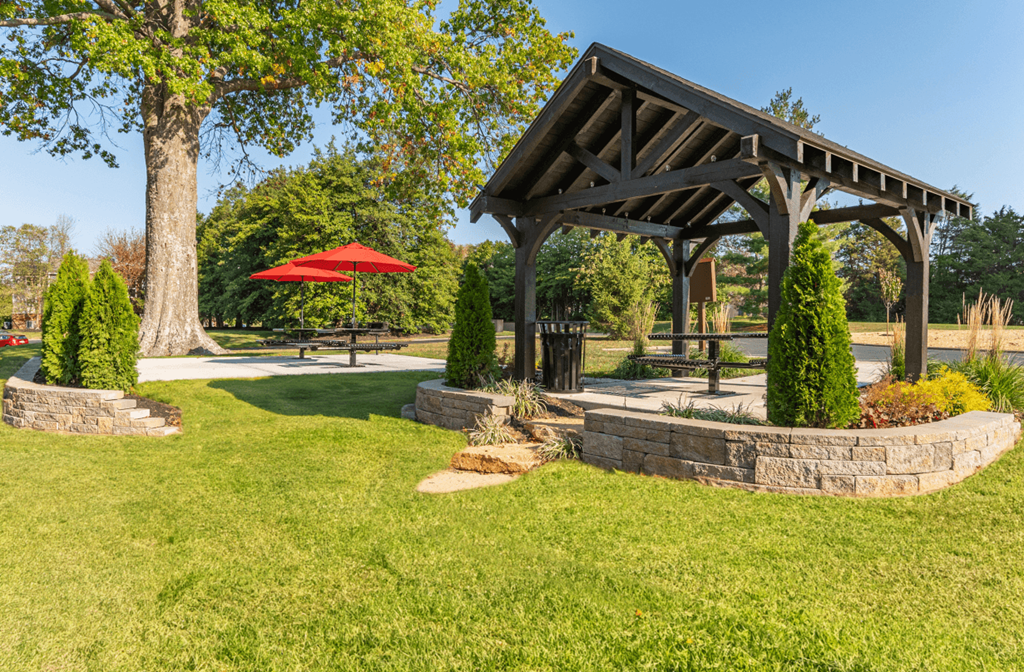 a pavilion with a picnic table and umbrella in a park at Weaver Farm, Florence, KY