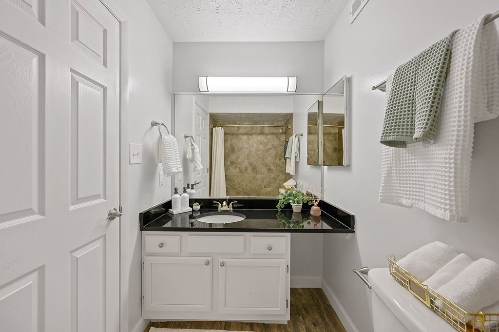 White bathroom with a black counter top and a mirror at Wrights Point, 41011