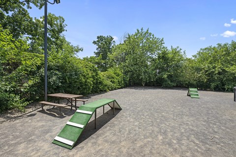 A playground with a green slide and a bench.
