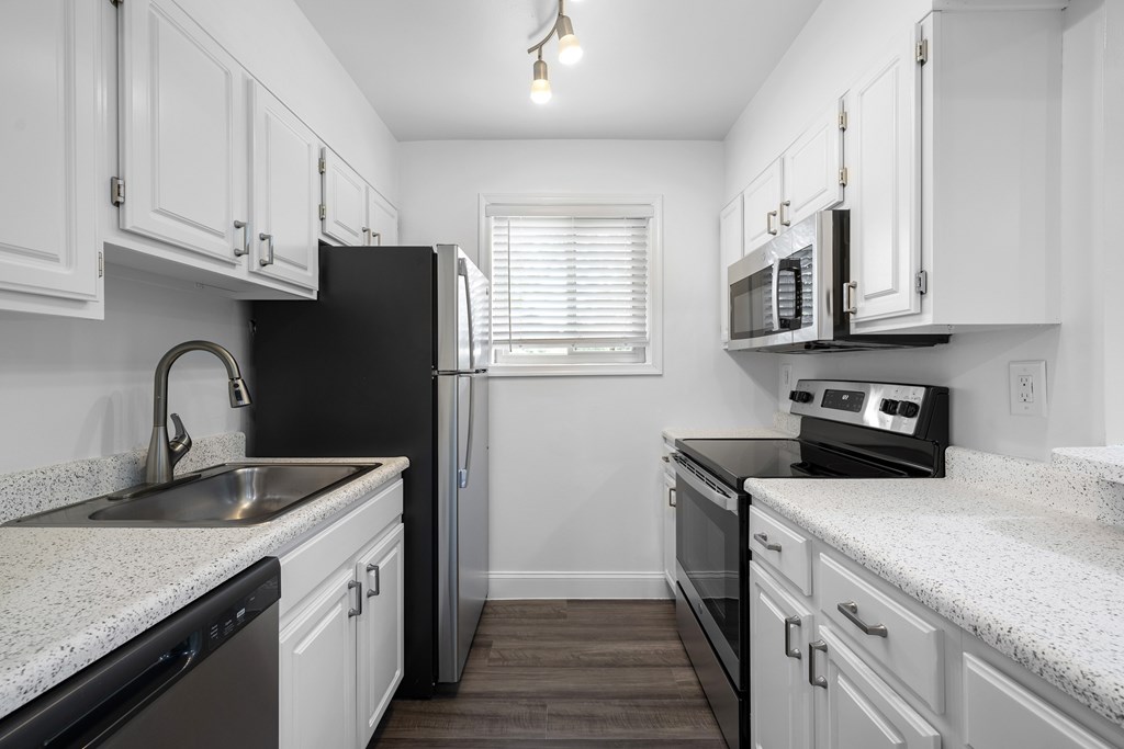 A kitchen with black appliances and white cabinets. at Bren Mar Apartments, Virginia