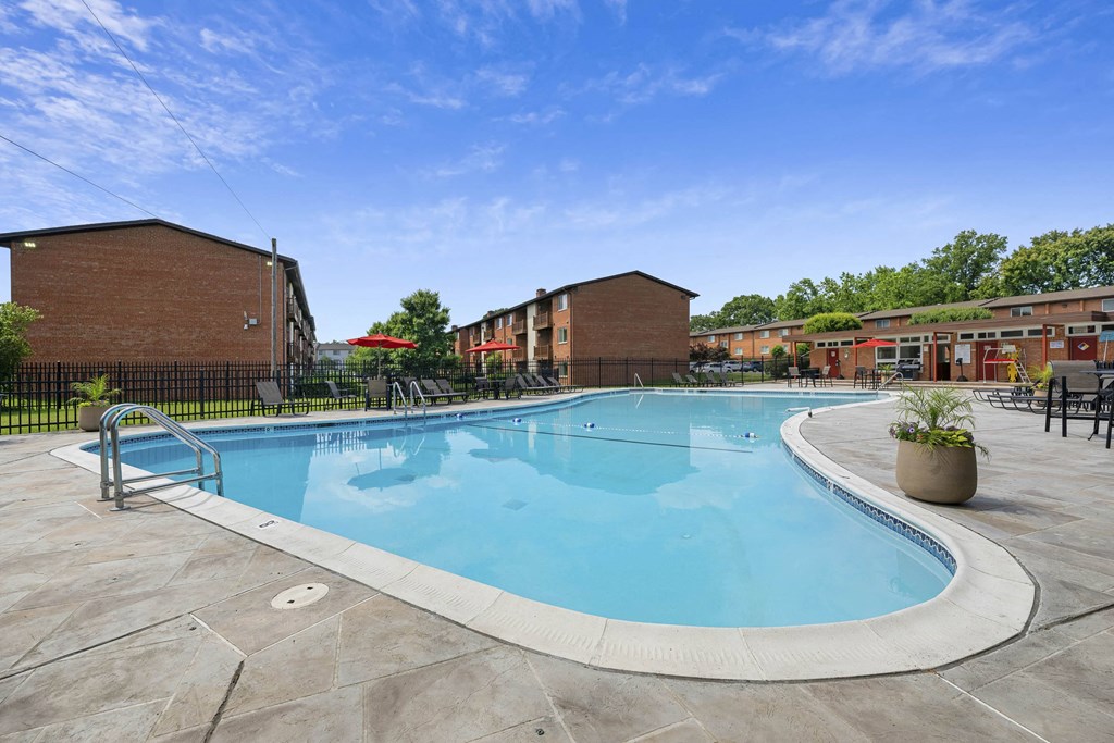 A swimming pool surrounded by a fence and buildings at Rose Hill Apartments, Virginia