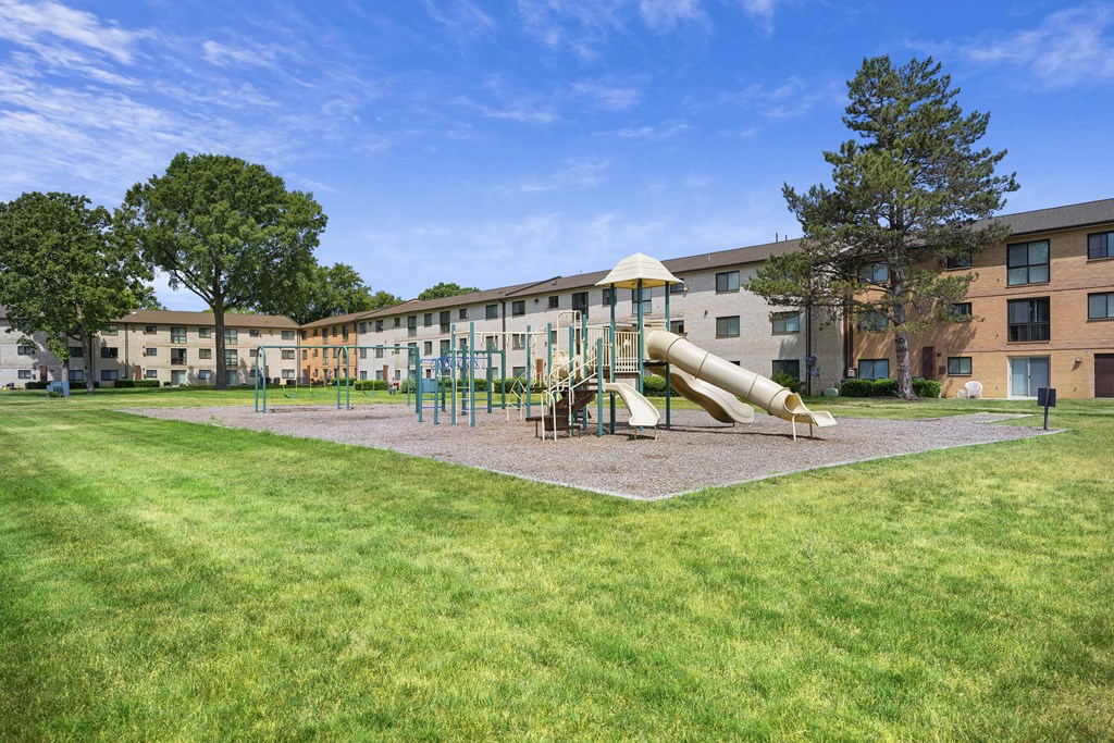 A playground with a slide and swings in front of a building at Rose Hill Apartments, Alexandria, 22310
