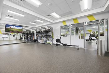 A gym with a variety of equipment including treadmills, weights, and exercise machines at Rose Hill Apartments, Alexandria, Virginia