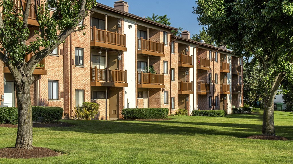 A large apartment complex with a green lawn in front at Rose Hill Apartments, Alexandria