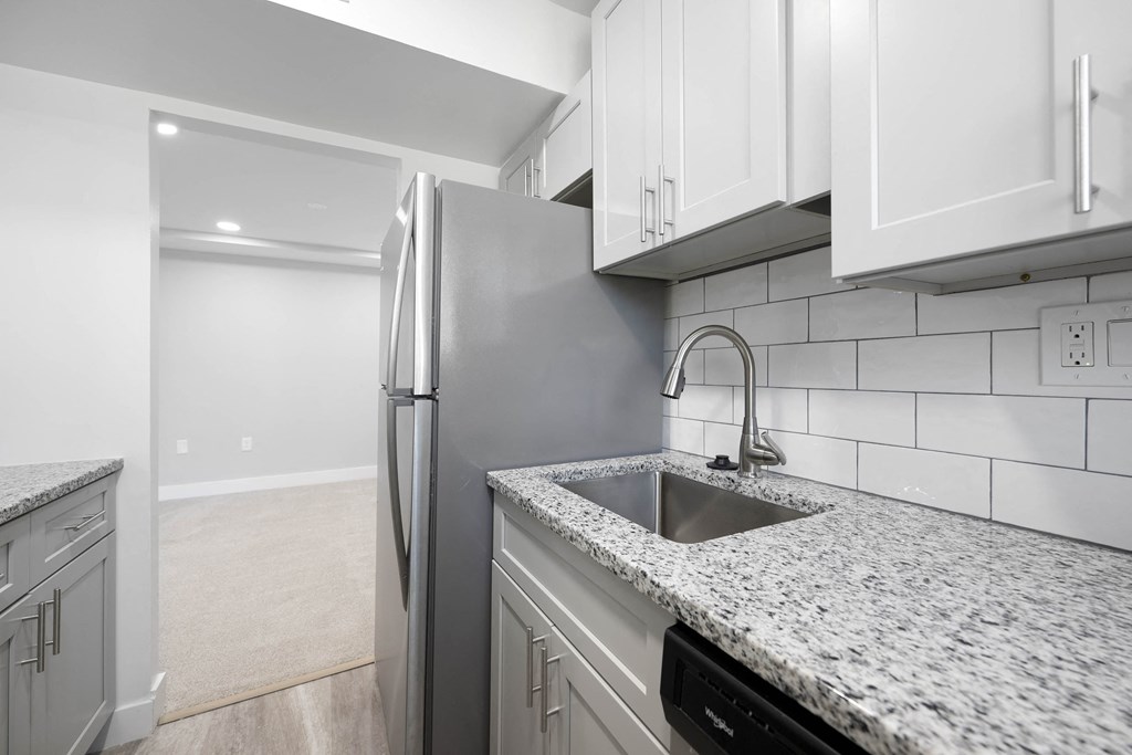 A kitchen with a granite countertop and a stainless steel refrigerator at Rose Hill Apartments, Alexandria, VA, 22310