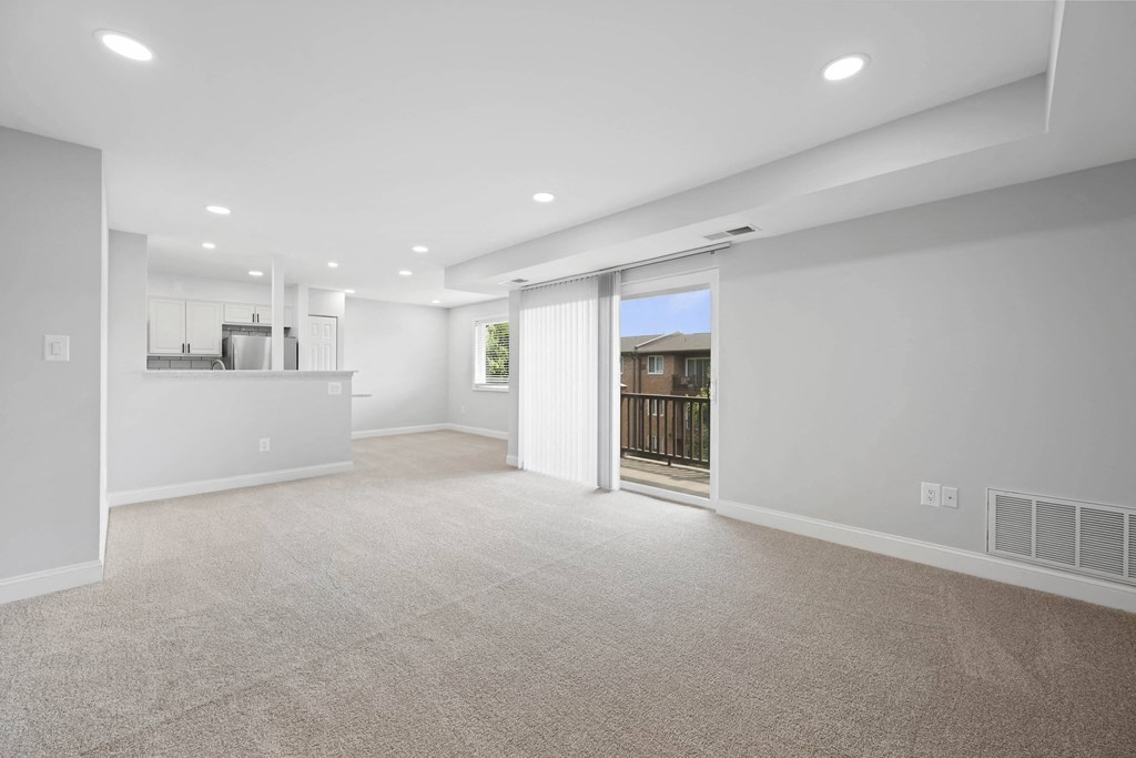 A spacious living room with a sliding glass door leading to a balcony at Rose Hill Apartments, Alexandria, VA, 22310