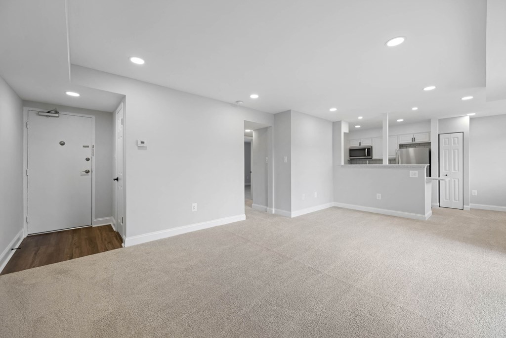 A spacious, empty room with white walls and carpeted floor at Rose Hill Apartments, Alexandria, Virginia