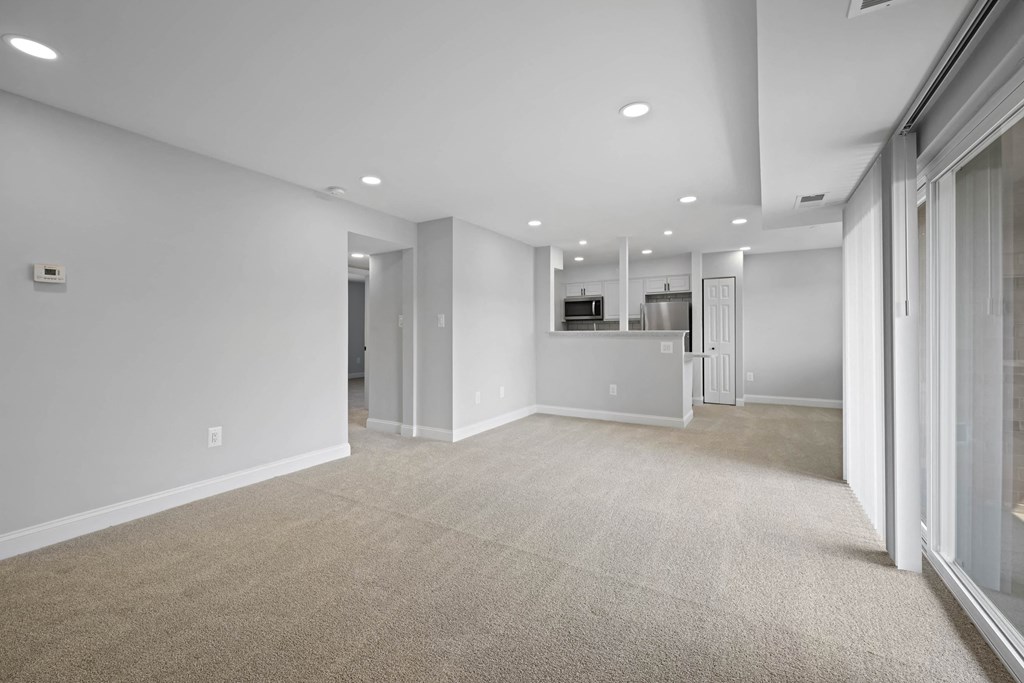 A spacious, empty room with a carpeted floor and white walls at Rose Hill Apartments, Alexandria, VA