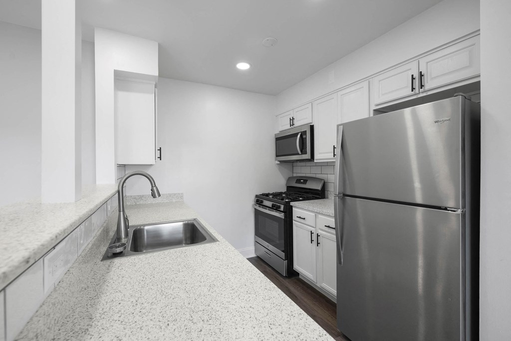 A modern kitchen with a stainless steel refrigerator, microwave, and oven at Rose Hill Apartments, Alexandria, VA, 22310