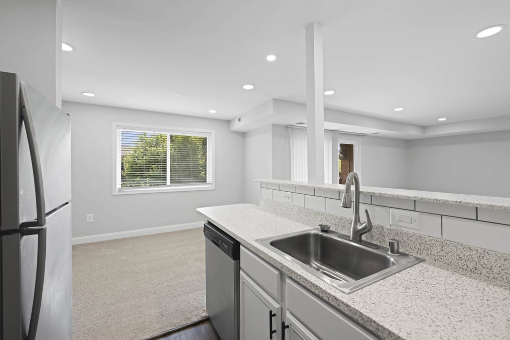 A modern kitchen with a stainless steel sink and refrigerator at Rose Hill Apartments, Alexandria
