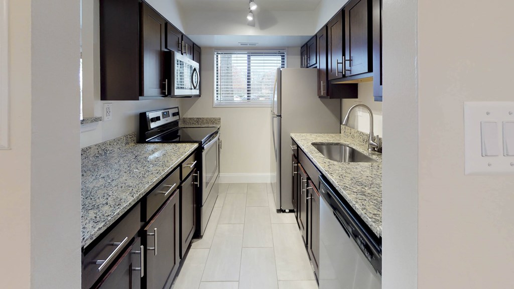 A kitchen with granite countertops and stainless steel appliances at Rose Hill Apartments, Virginia