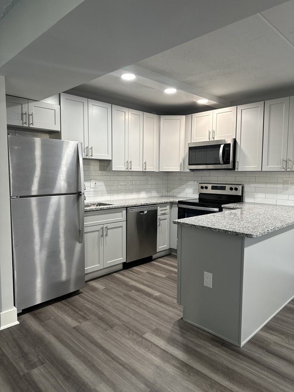 Renovated kitchen with stainless steel appliances and upgraded cabinets, flooring, and  counter tops at Stuart Woods* Apartments, Herndon, 20170