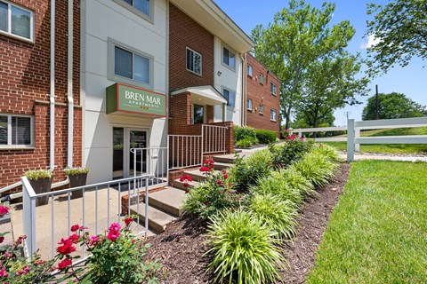 A red brick building with a green sign that says Bren Mar Apartments.