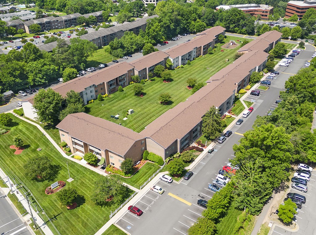 an aerial view of a building with a green lawn and a parking lot at Gainsborough Court Apartments, Fairfax, VA