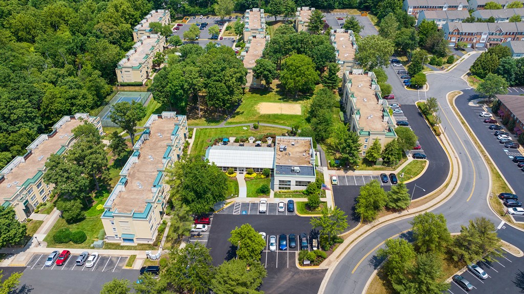 an aerial view of a neighborhood with cars parked in a parking lot at Stuart Woods* Apartments, Herndon, Virginia
