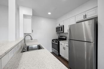 a kitchen with stainless steel appliances and white counter tops at Rose Hill Apartments, Virginia