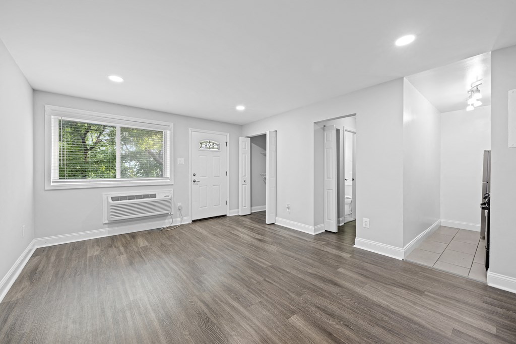 an empty living room with white walls and a window
