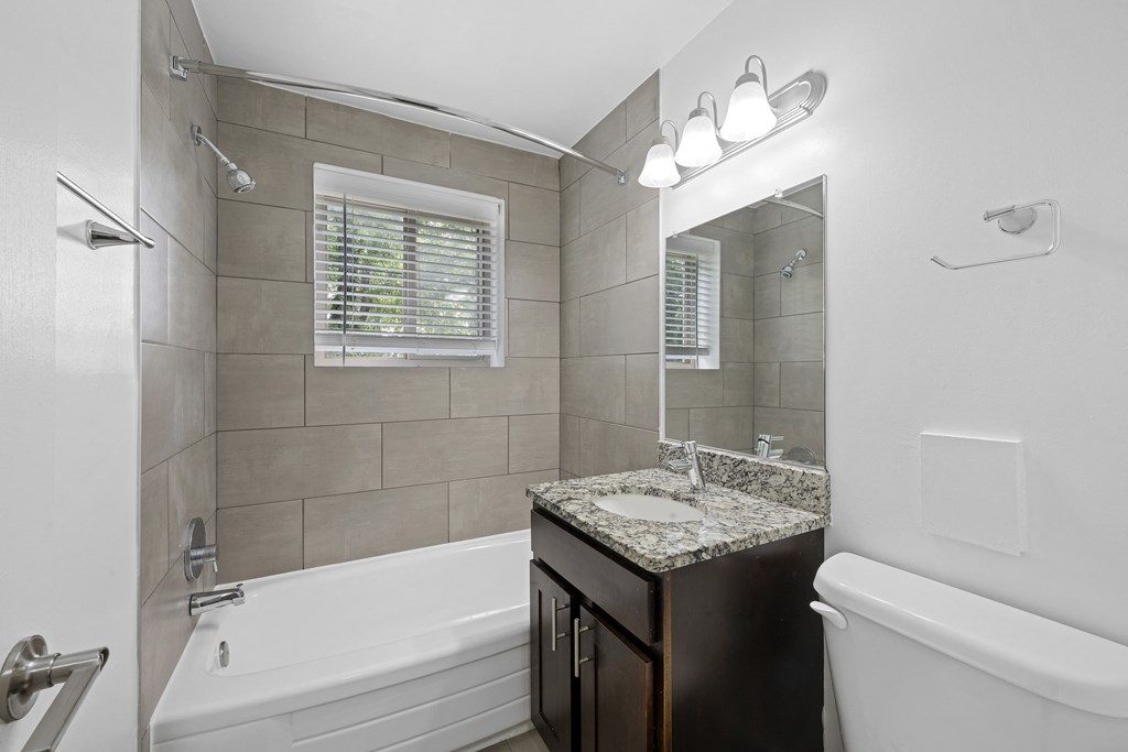 a bathroom with a tub and a sink and a mirror