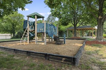 a playground with a blue playset and a swing set