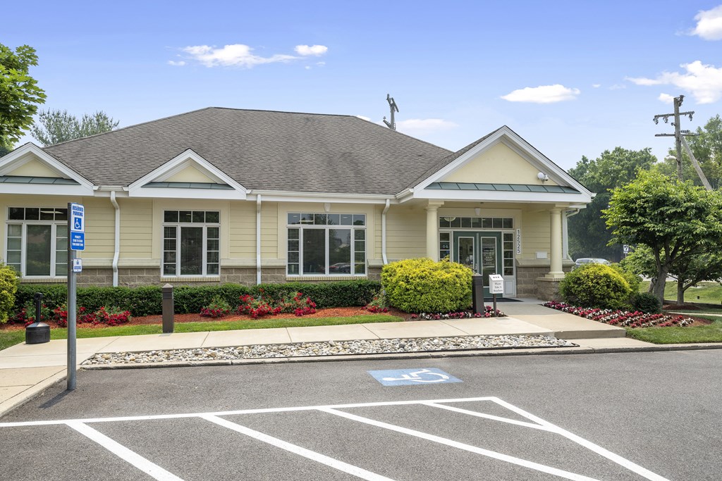 a house with a parking lot and a street sign in front of it