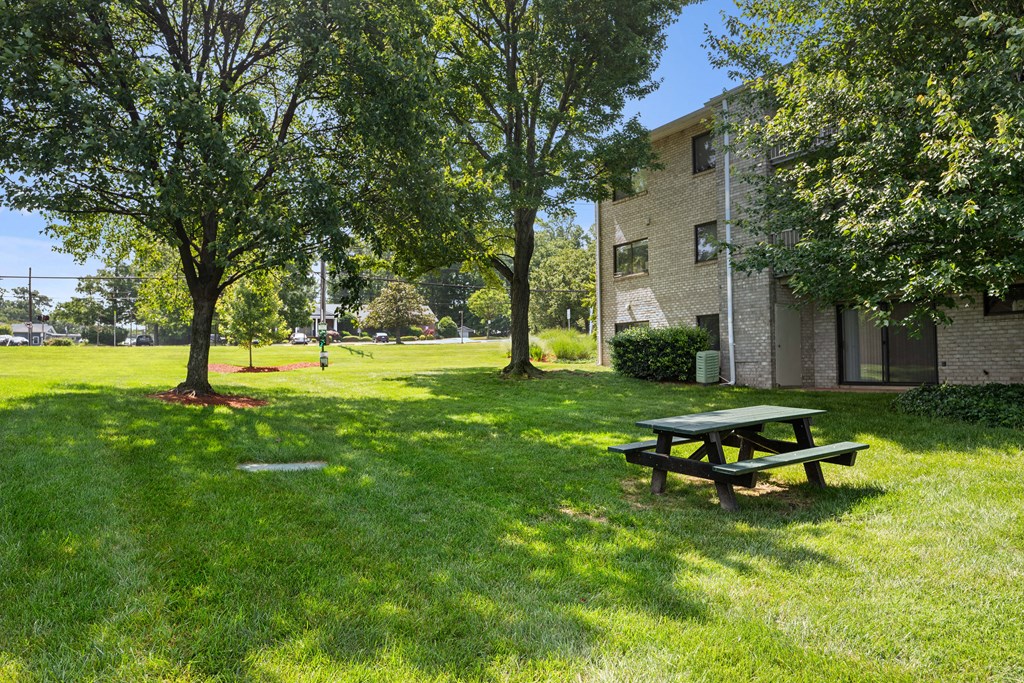 a picnic table in the grass in front of a building at Gainsborough Court Apartments, Fairfax