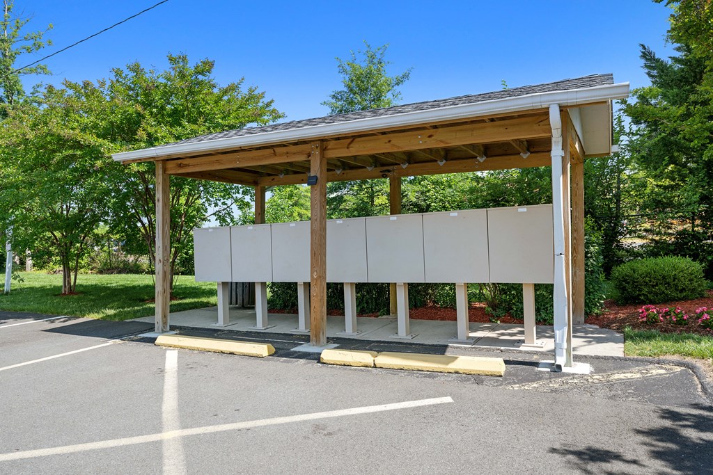 a bus stop with a roof and benches in a parking lot at Gainsborough Court Apartments, Fairfax, VA