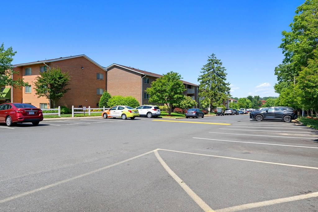 a parking lot with cars parked in front of a building at Gainsborough Court Apartments, Virginia, 22030
