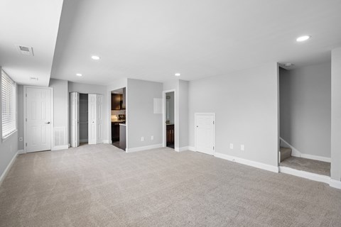 a living room with a carpeted floor and white walls