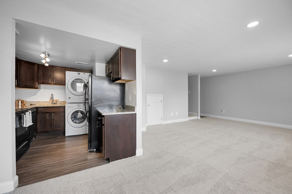 a renovated living room with a washer and dryer and a kitchen at Gainsborough Court Apartments, Fairfax, VA