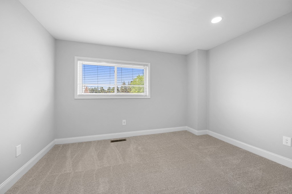 an empty room with carpet and a window at Gainsborough Court Apartments, Fairfax, Virginia
