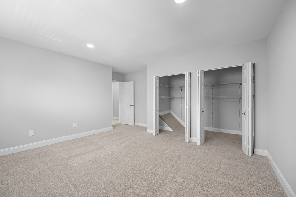 a room with a carpeted floor and a closet with mirrored doors at Gainsborough Court Apartments, Virginia, 22030